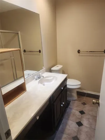 a bathroom with a sink a toilet a mirror and shower