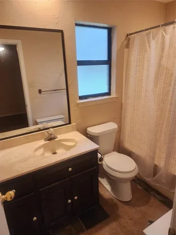 a bathroom with a sink a toilet and shower curtain