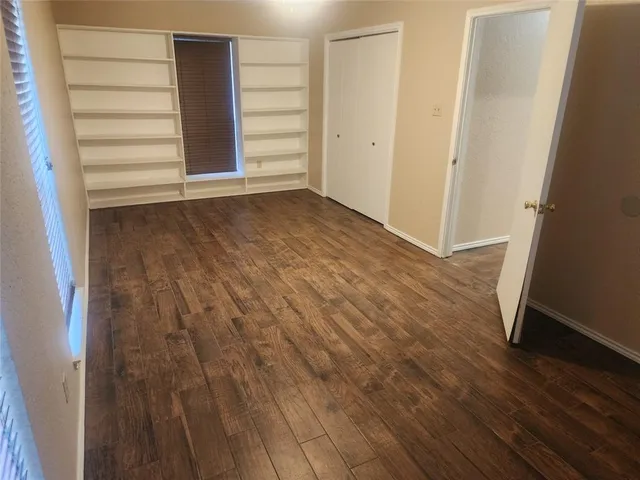 an empty room with wooden floor and closet