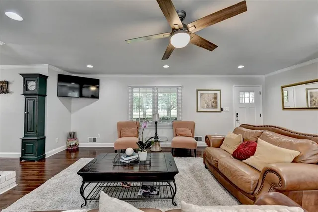 a kitchen with stainless steel appliances granite countertop a stove top oven a refrigerator a sink and chairs with wooden floor