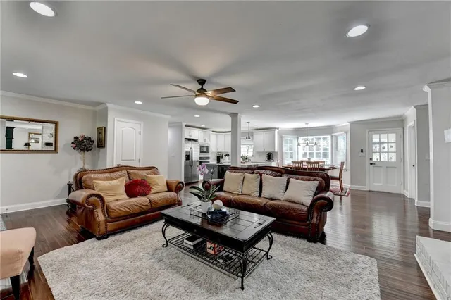 a kitchen with stainless steel appliances kitchen island granite countertop a dining table chairs and sink