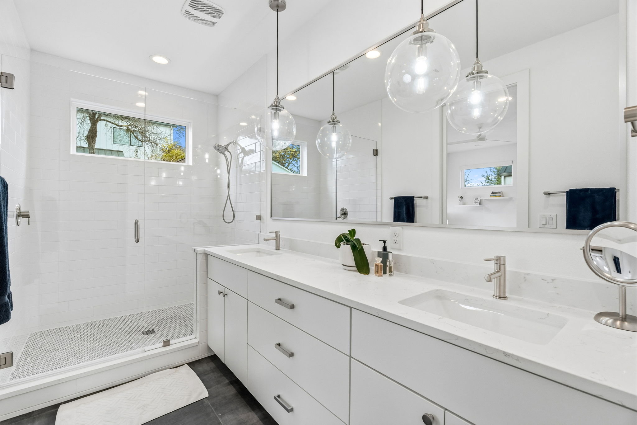 2508 Paramount Avenue, Unit B Austin, TX 78704 - Photo 21 of 40 The main floor primary ensuite bath is a luxury inspired getaway with gorgeous designer finishes, a quartz topped vanity, and large frameless glass enclosed walk-in shower with tile surround.
