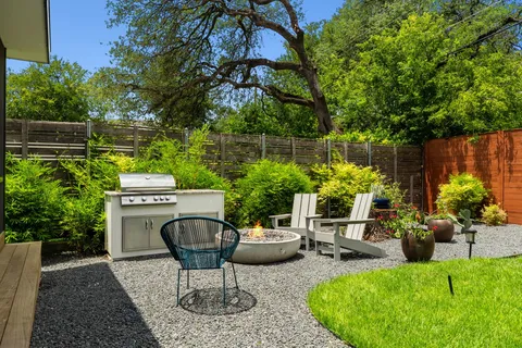 a view of a backyard with plants and patio