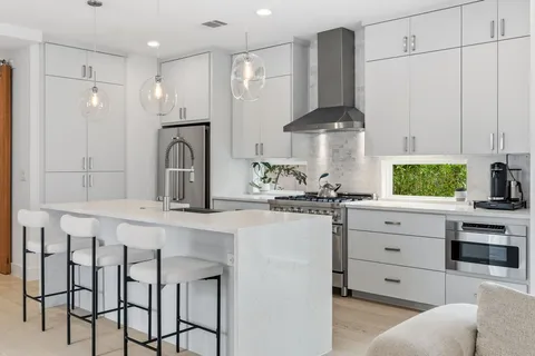 a kitchen with stainless steel appliances a sink stove and cabinets