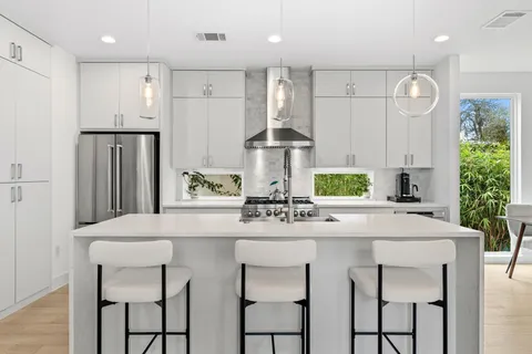 a kitchen with stainless steel appliances a sink stove and refrigerator
