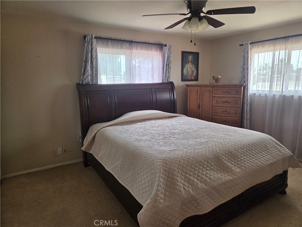 13955 Iroquois Road Apple Valley, CA 92307 - Photo 11 of 19 a bedroom with a large bed and a window