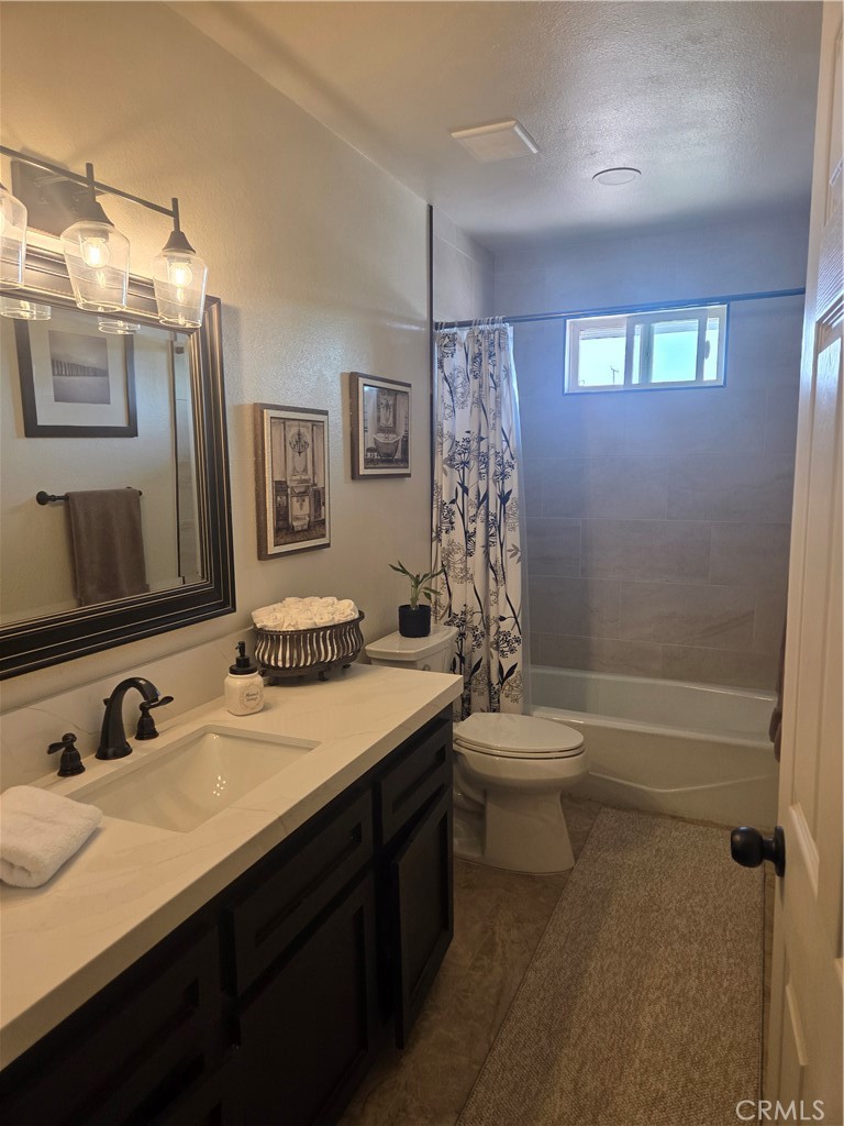 13955 Iroquois Road Apple Valley, CA 92307 - Photo 12 of 19 a bathroom with a sink a toilet a mirror a vanity and shower