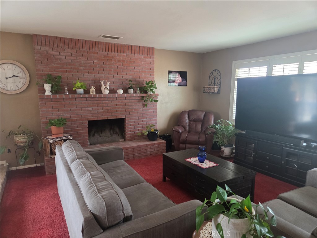 13955 Iroquois Road Apple Valley, CA 92307 - Photo 4 of 19 a living room with furniture a fireplace and a flat screen tv