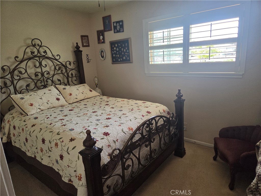 13955 Iroquois Road Apple Valley, CA 92307 - Photo 9 of 19 a bedroom with a bed a couch and a window