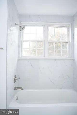 a bathroom with a bathtub and a window