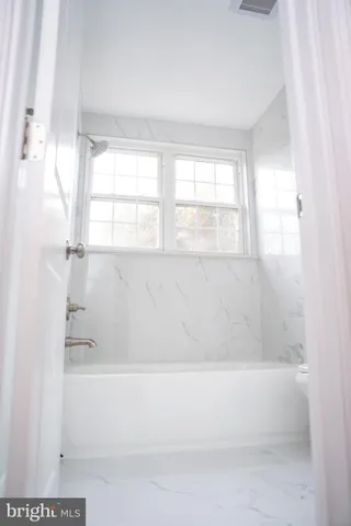 a bathroom with bathtub and window