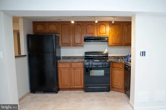 a kitchen with stainless steel appliances granite countertop a refrigerator and a stove top oven