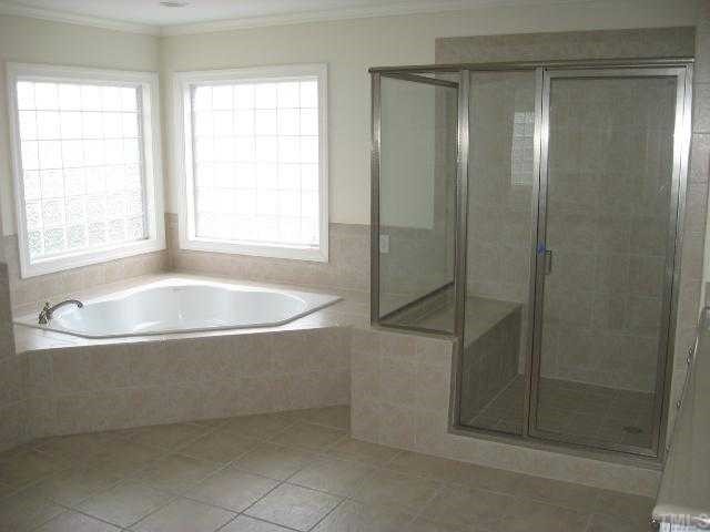 2916 Elmfield Street Raleigh, NC 27614 - Photo 8 of 10 The spacious Master bath features a huge jet tub as well as a sit down, tiled stall shower, tiled flooring and solid surface countertops.