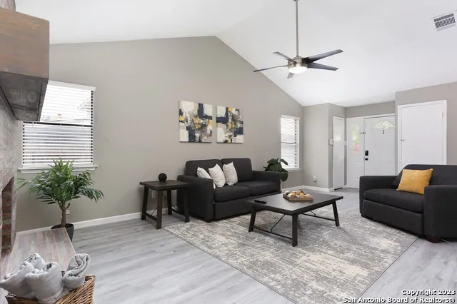 a living room with furniture a window and a potted plant