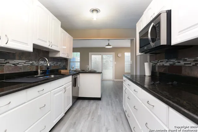 a kitchen with stainless steel appliances kitchen island granite countertop a sink and cabinets