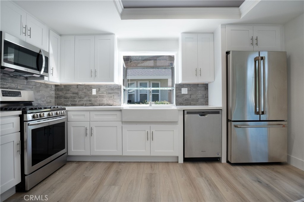 13 Brookmont, Unit 60 Irvine, CA 92604 - Photo 12 of 27 a kitchen with stainless steel appliances a refrigerator microwave and sink