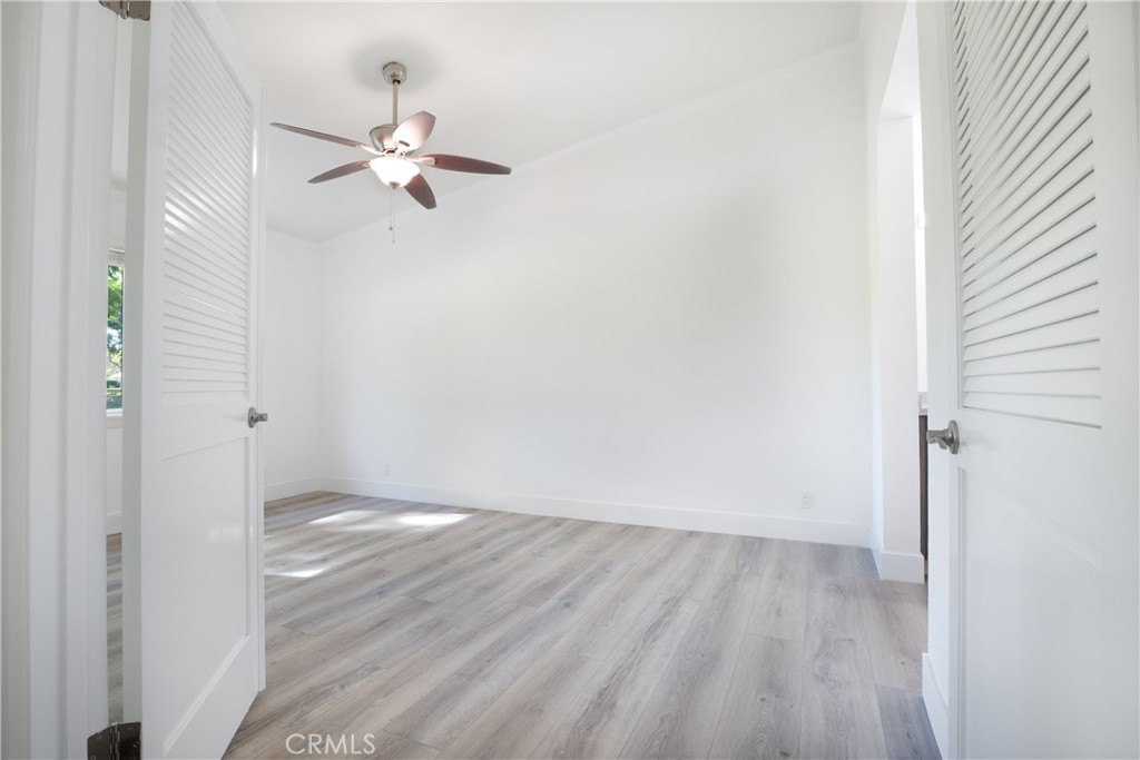 13 Brookmont, Unit 60 Irvine, CA 92604 - Photo 18 of 27 a view of a room with wooden floor closet and a ceiling fan