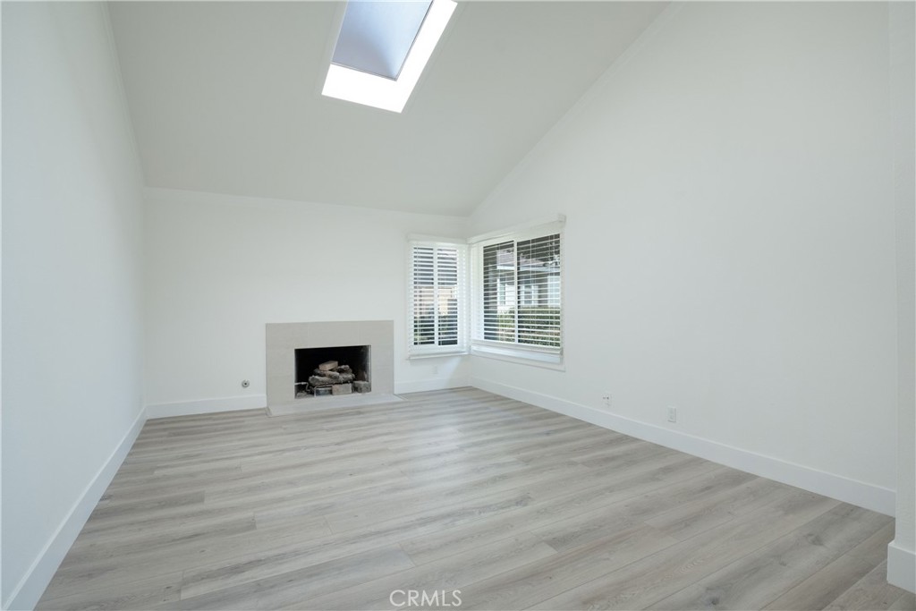 13 Brookmont, Unit 60 Irvine, CA 92604 - Photo 5 of 27 an empty room with wooden floor and a fireplace