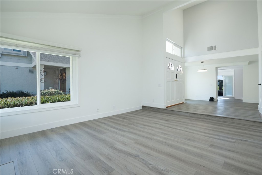 13 Brookmont, Unit 60 Irvine, CA 92604 - Photo 8 of 27 an empty room with wooden floor and windows