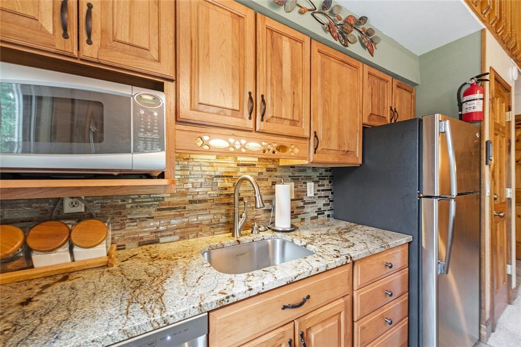 760 Columbine Road, Unit A12 Breckenridge, CO 80424 - Photo 20 of 35 a kitchen with granite countertop a refrigerator and a sink