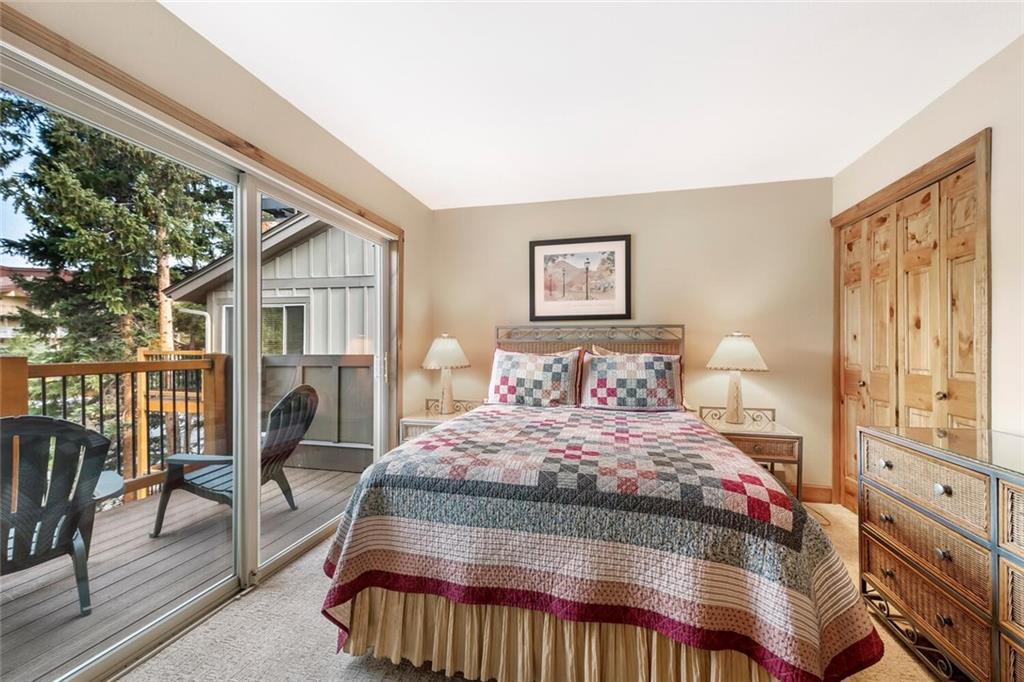760 Columbine Road, Unit A12 Breckenridge, CO 80424 - Photo 3 of 35 a bedroom with a bed a mirror and furniture