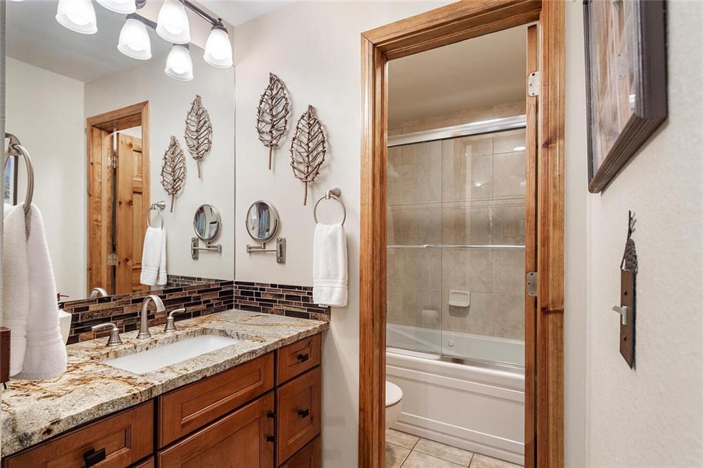 760 Columbine Road, Unit A12 Breckenridge, CO 80424 - Photo 23 of 35 a bathroom with a granite countertop sink a mirror and a shower