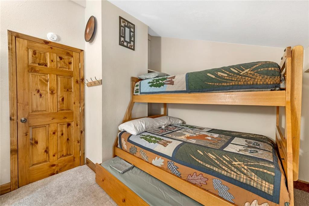760 Columbine Road, Unit A12 Breckenridge, CO 80424 - Photo 6 of 35 a bedroom with a bed and a dresser