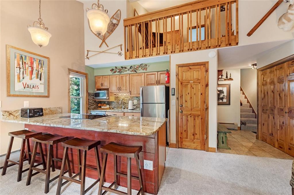 760 Columbine Road, Unit A12 Breckenridge, CO 80424 - Photo 7 of 35 a kitchen with stainless steel appliances granite countertop a refrigerator and a stove top oven