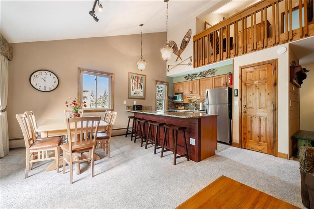 760 Columbine Road, Unit A12 Breckenridge, CO 80424 - Photo 9 of 35 a living room with a table chairs and a refrigerator