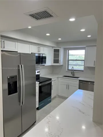 a bathroom with a granite countertop sink and mirror