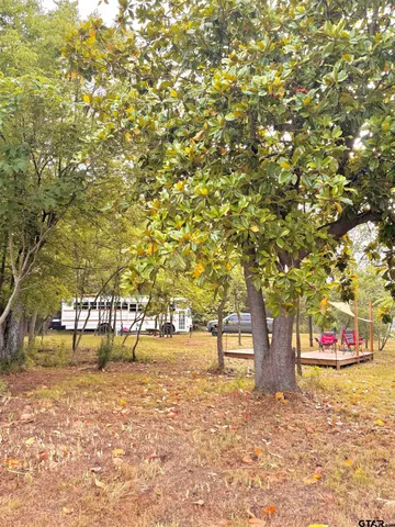 a view of a large pool with lawn chairs under an umbrella