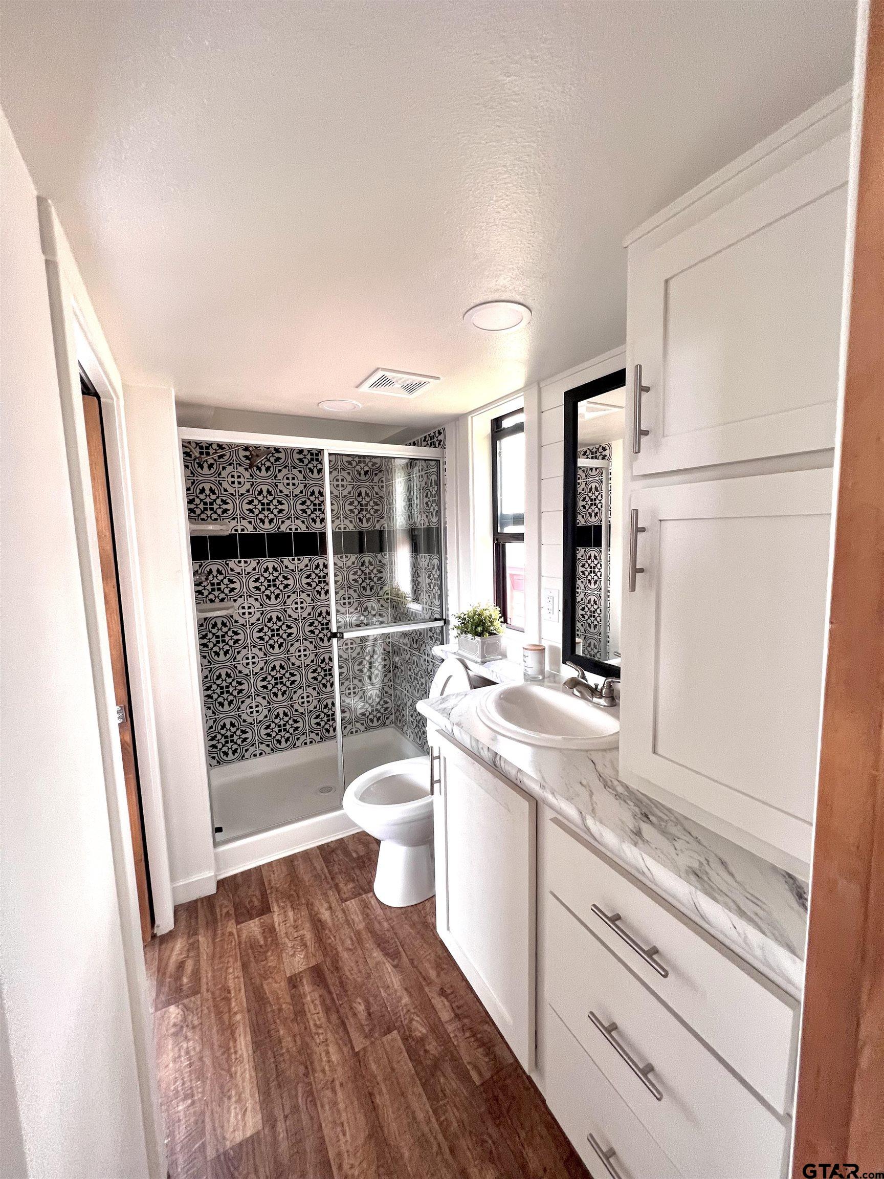 3235 County Road Cookville, TX 75558 - Photo 34 of 38 a bathroom with a sink a toilet and shower
