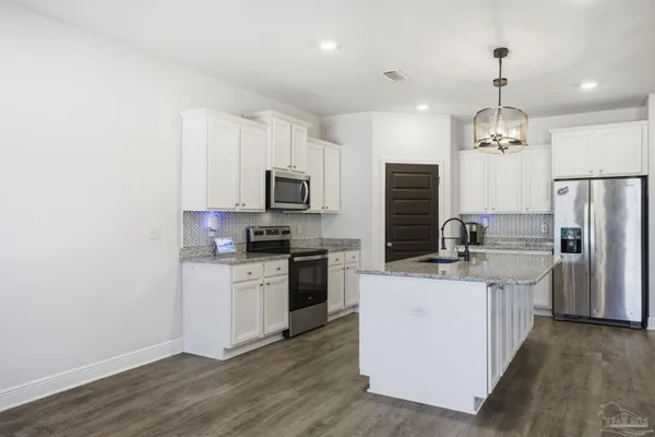 a kitchen with a sink stainless steel appliances and white cabinets