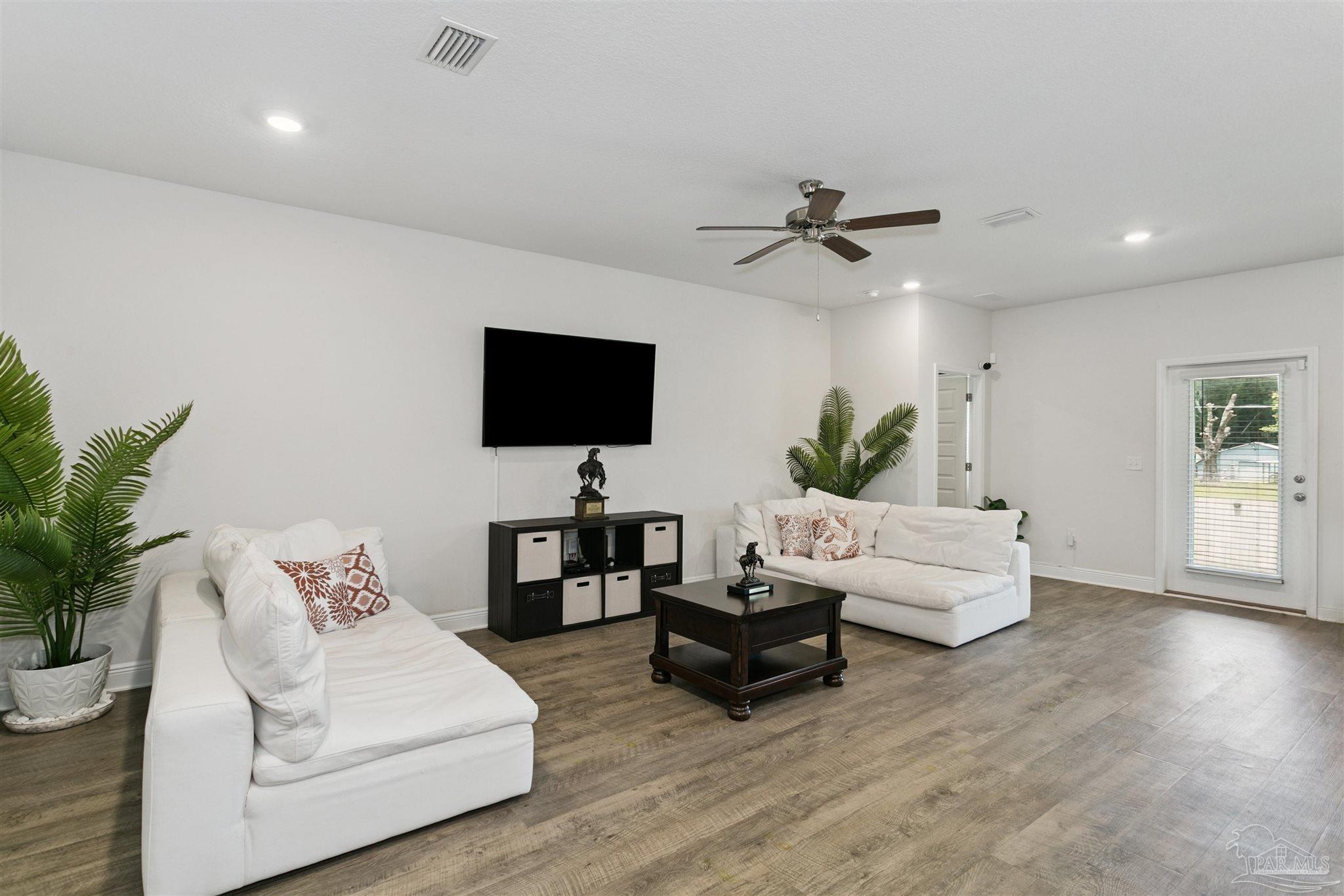 8038 Burnside Loop Pensacola, FL 32526 - Photo 15 of 48 a living room with furniture a ceiling fan and a flat screen tv