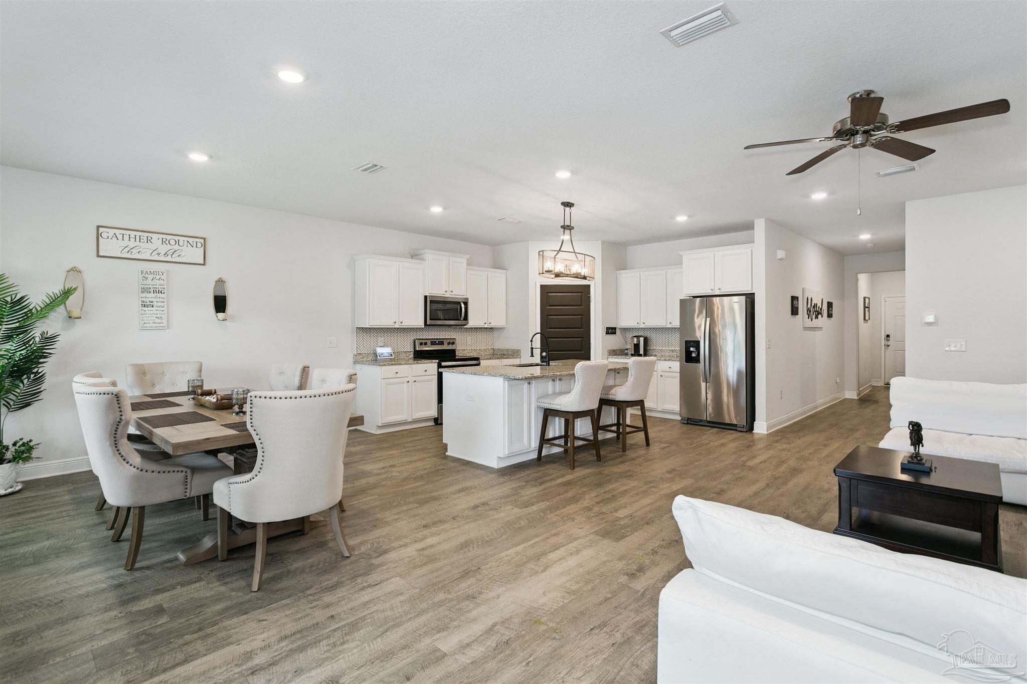 8038 Burnside Loop Pensacola, FL 32526 - Photo 20 of 48 a living room with couches kitchen view and kitchen view with wooden floor