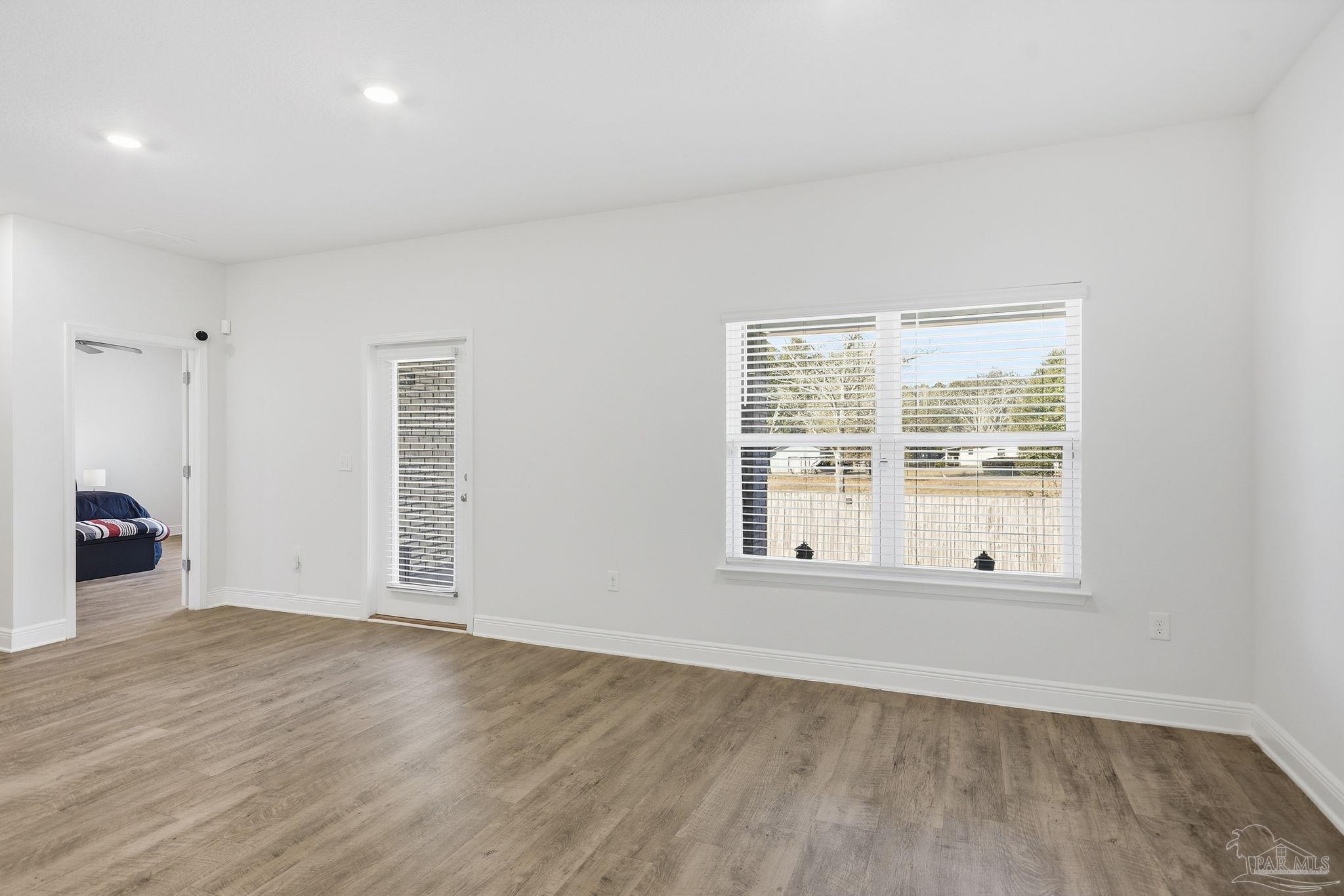 8038 Burnside Loop Pensacola, FL 32526 - Photo 23 of 48 an empty room with wooden floor and windows