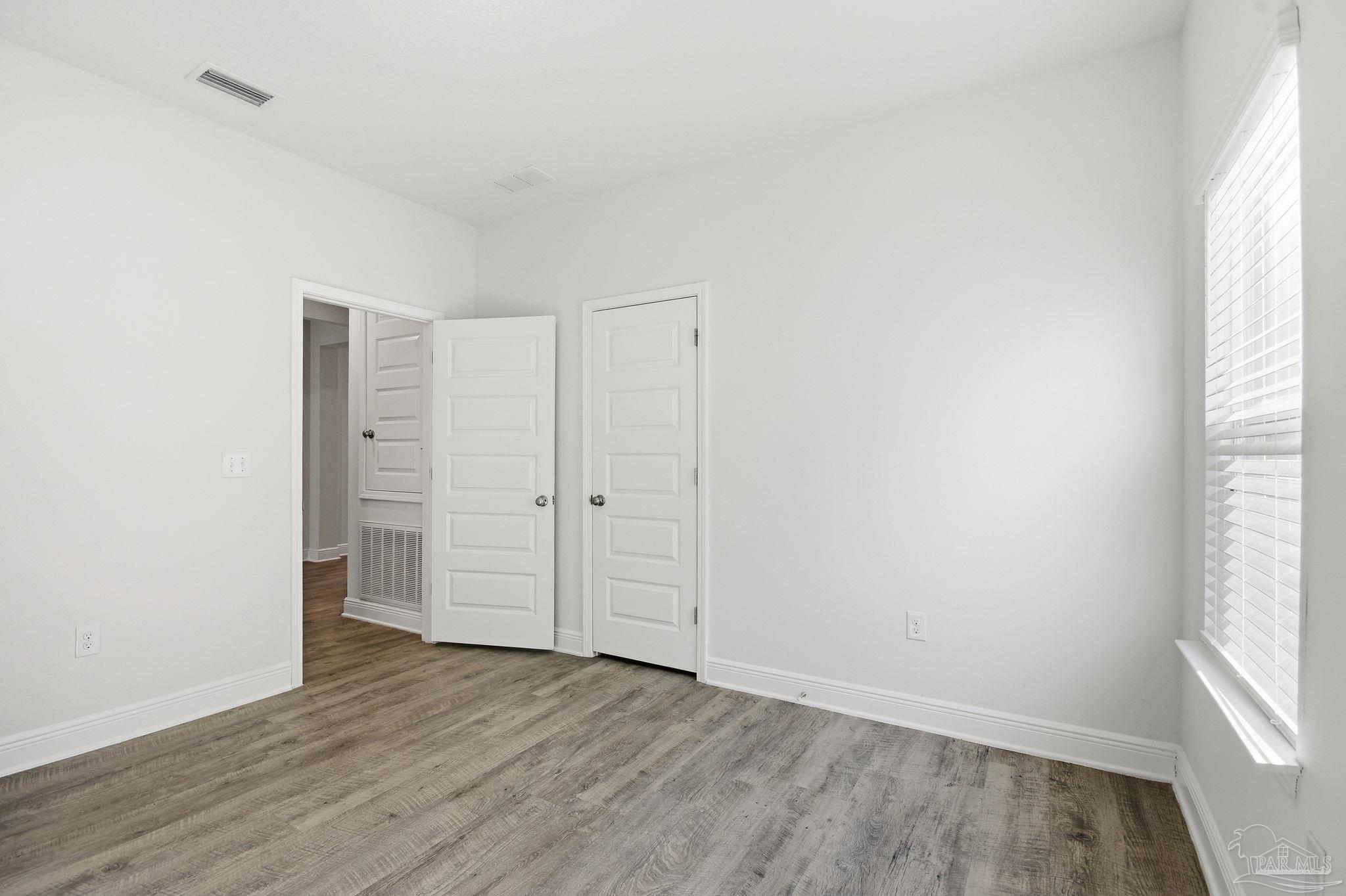 8038 Burnside Loop Pensacola, FL 32526 - Photo 31 of 48 an empty room with wooden floor and windows