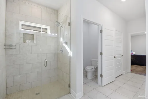 a bathroom with a granite countertop shower and toilet