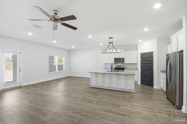 an open kitchen with refrigerator and microwave