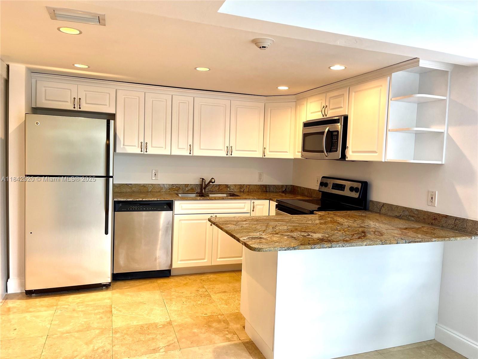 607 Ocean Drive, Unit 3K Key Biscayne, FL 33149 - Photo 14 of 18 a kitchen with stainless steel appliances granite countertop a refrigerator a stove and a sink