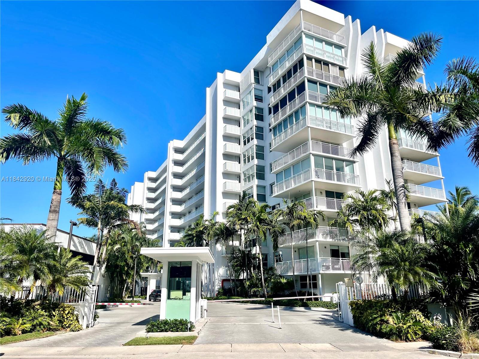 607 Ocean Drive, Unit 3K Key Biscayne, FL 33149 - Photo 2 of 18 a front view of multi story residential apartment building with a yard