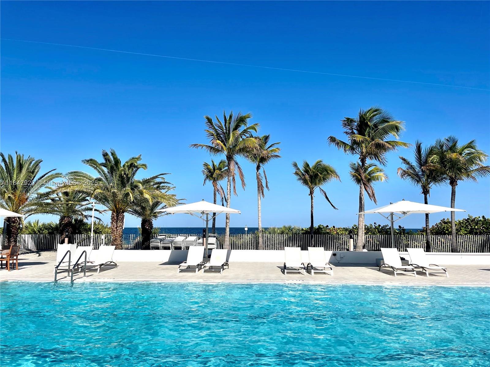 607 Ocean Drive, Unit 3K Key Biscayne, FL 33149 - Photo 5 of 18 a view of a swimming pool and lounge chairs