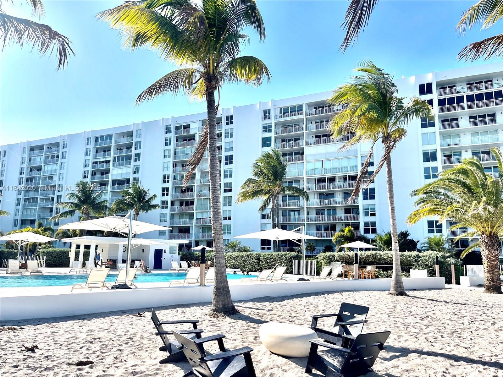 607 Ocean Drive, Unit 3K Key Biscayne, FL 33149 - Photo 10 of 18 a view of a tall building with a palm tree and outdoor space