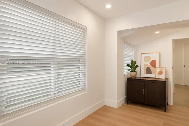 a view of a bedroom with a window and wooden floor