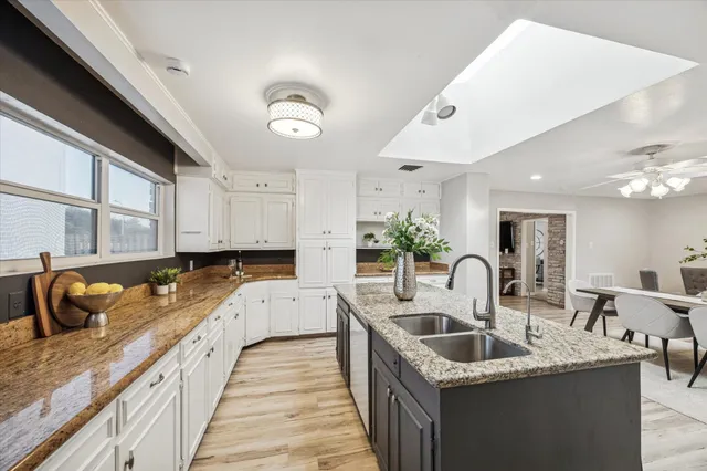 a kitchen with granite countertop a sink a counter space and cabinets