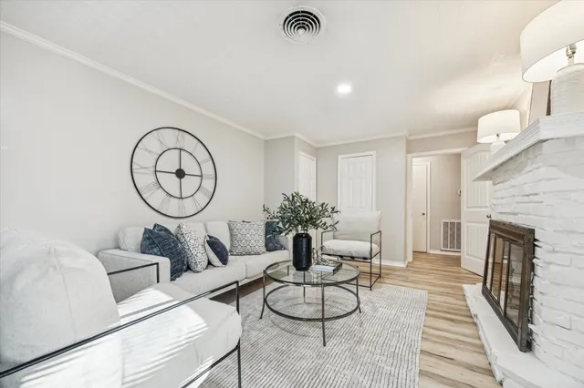 a living room with furniture a fireplace and a chandelier