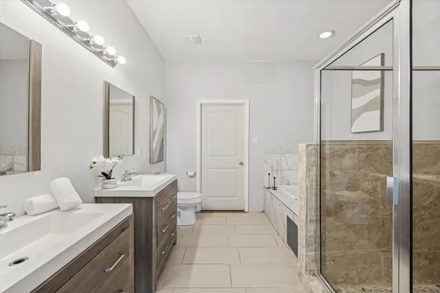 a bathroom with a double vanity sink a large mirror a shower and bathtub