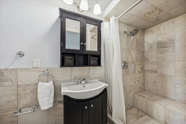 a bathroom with a granite countertop sink a toilet and shower