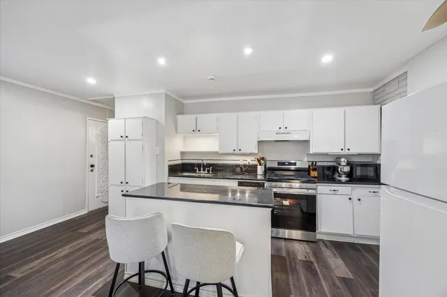 a view of a livingroom with wooden floor and a ceiling fan
