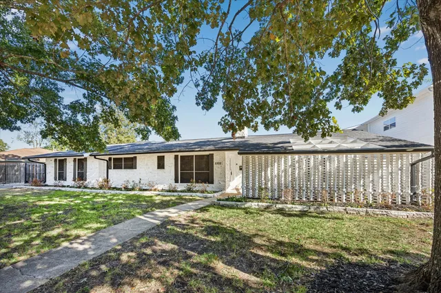 a front view of a house with a garden and yard